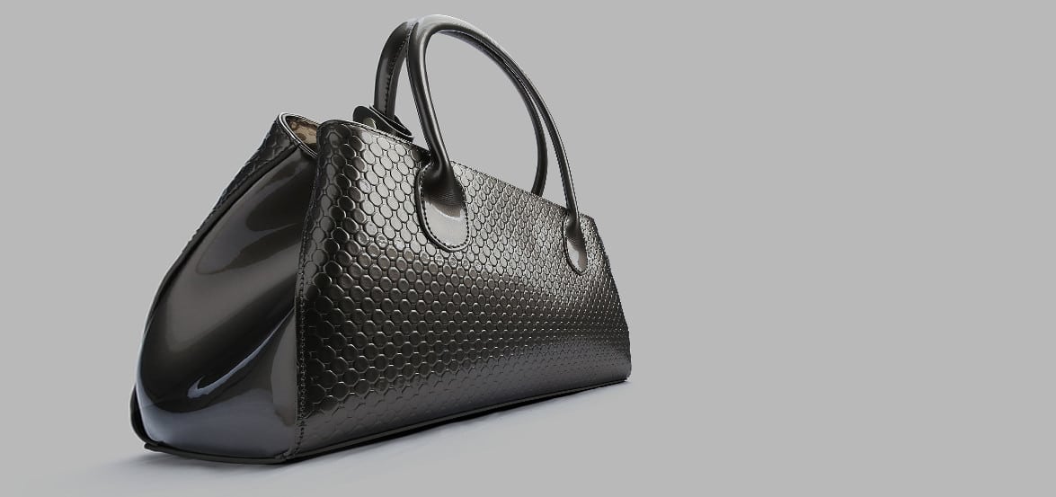 Sac à main en cuir noir avec un motif texturé hexagonal élégant.