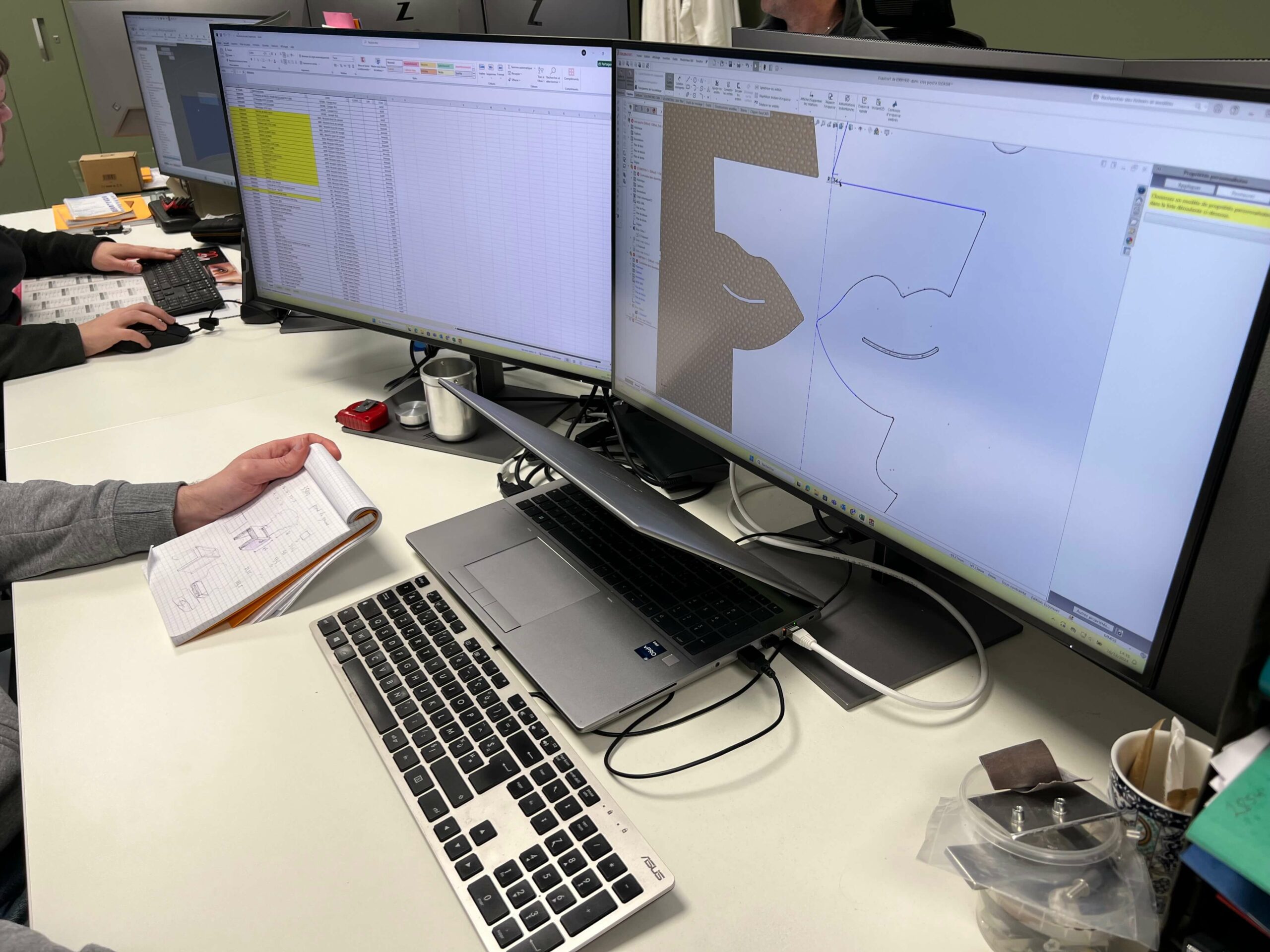 Un employé travaille sur des dessins techniques et un tableau Excel affichés sur deux écrans.