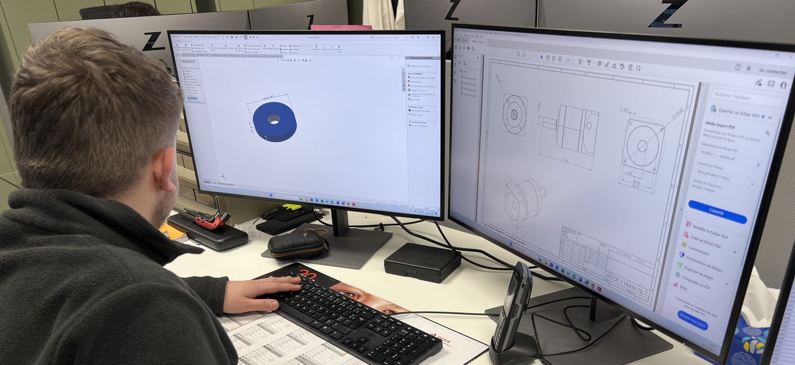 Un homme travaillant sur un logiciel de modélisation 3D sur deux écrans.